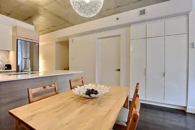 a dining room with a wooden table and chairs at Highrise 1BDR Condo in Downtown Montreal - Long Term Stay by M11 in Montréal