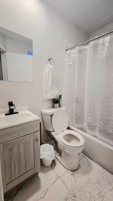 a white bathroom with a toilet and a sink at Private rooms in a shared two bedrooms apartment in Montréal