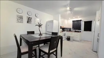 a kitchen with a table and chairs and a refrigerator at Private rooms in a shared two bedrooms apartment in Montréal
