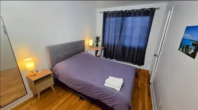 a bedroom with a purple bed and a window at Private rooms in a shared two bedrooms apartment in Montréal