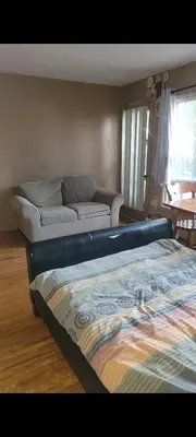 a living room with a bed and a couch at Very large room in Montréal