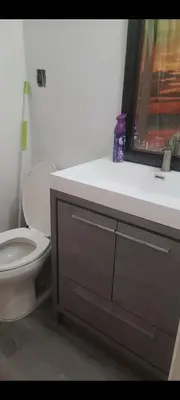 a bathroom with a toilet and a sink with a window at small modern 2 bedrooms in Montréal