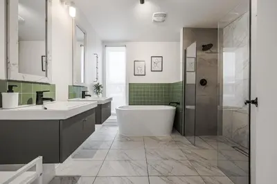 a bathroom with a tub and two sinks and a shower at 4 bedrooms 2 floors Fully Renovated Apartment in Montréal