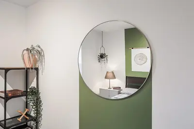 a mirror hanging on a wall next to a room at 4 bedrooms 2 floors Fully Renovated Apartment in Montréal