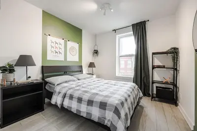 a bedroom with a bed and a desk and a window at 4 bedrooms 2 floors Fully Renovated Apartment in Montréal
