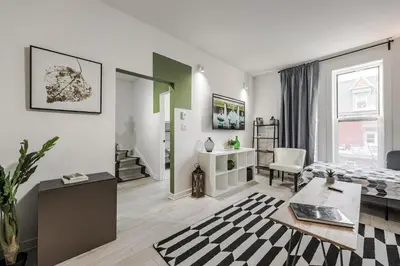 a living room with a bed and a table at 4 bedrooms 2 floors Fully Renovated Apartment in Montréal