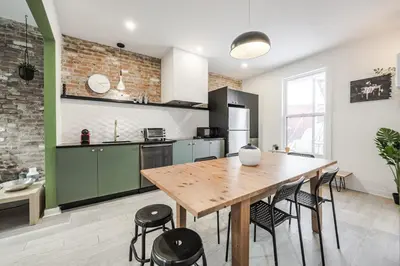 a kitchen with a wooden table and some chairs at 4 bedrooms 2 floors Fully Renovated Apartment in Montréal
