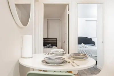 a white table in a room with a mirror at Griffintown Urban Nest 2BR Comfort in Montréal