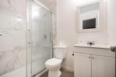 a bathroom with a toilet and a shower and a sink at Griffintown Urban Nest 2BR Comfort in Montréal