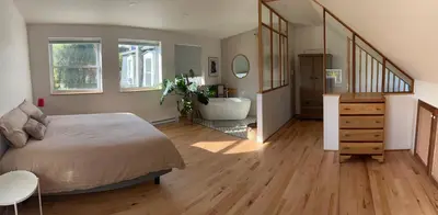 a bedroom with a bed and a bathroom with a tub at Loft à la campagne in Waterville