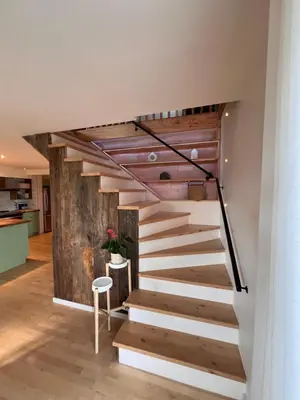 a staircase in a house with a wooden wall at Loft à la campagne in Waterville