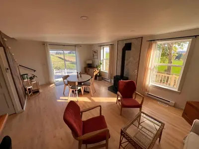 a living room with a table and chairs at Loft à la campagne in Waterville
