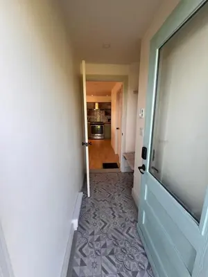 a hallway with a door leading to a kitchen at Loft à la campagne in Waterville