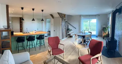 a kitchen and living room with a table and chairs at Loft à la campagne in Waterville