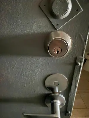 a metal door with a toilet in a bathroom at Appartment 1 bedroom in Longueuil