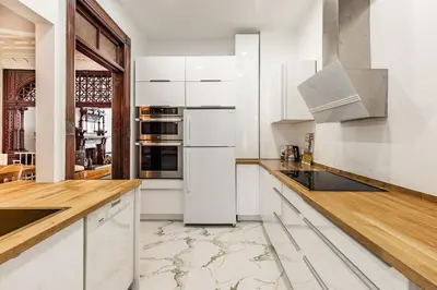a white kitchen with white cabinets and appliances at Au coeur du plateau in Montréal