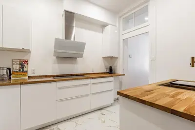 a kitchen with white cabinets and a wooden counter top at Au coeur du plateau in Montréal