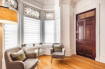 a living room with two chairs and a door at Au coeur du plateau in Montréal