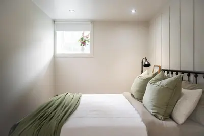 a bedroom with a bed with white sheets and a window at Historical Home - Near Montreal in Longueuil