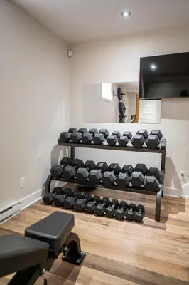 a gym with a rack of dumbbells at Historical Home - Near Montreal in Longueuil