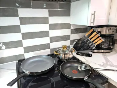 a frying pan on top of a stove in a kitchen at Stylish & Modern Condo - FREE Parking & EV Chargers in Laval