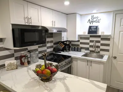 a kitchen with a bowl of fruit on a counter at Stylish & Modern Condo - FREE Parking & EV Chargers in Laval