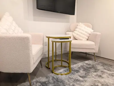 a living room with two chairs and a table at Stylish & Modern Condo - FREE Parking & EV Chargers in Laval