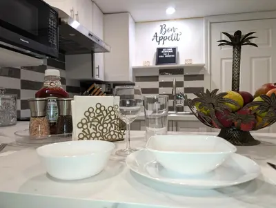 a kitchen counter with two white bowls and wine glasses at Stylish & Modern Condo - FREE Parking & EV Chargers in Laval