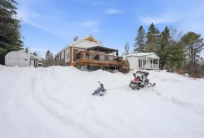 a snowmobile parked in the snow in front of a house at 232 on the Lake Ski, Golf, Snowmobile in Adstock