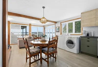 a kitchen and dining room with a table and a washing machine at 232 on the Lake Ski, Golf, Snowmobile in Adstock
