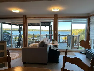 a living room with a couch and a view of the water at 232 on the Lake Ski, Golf, Snowmobile in Adstock
