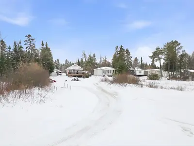 a dirt road in the snow with houses and trees at 232 on the Lake Ski, Golf, Snowmobile in Adstock