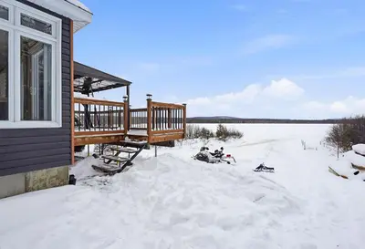 a house with a deck in the snow at 232 on the Lake Ski, Golf, Snowmobile in Adstock