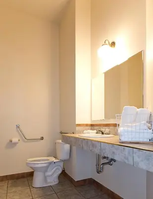 a bathroom with a sink and a toilet and a mirror at Motel De La Gare Richmond in Richmond