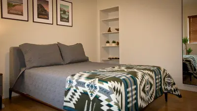 a bedroom with a bed with a blanket on it at Motel De La Gare Richmond in Richmond