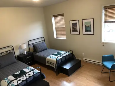 a bedroom with two beds and a chair in it at Motel De La Gare Richmond in Richmond