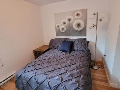 a bedroom with a bed with a blue pillow at L'EMERAUDE sur la rivière Magog in Sherbrooke