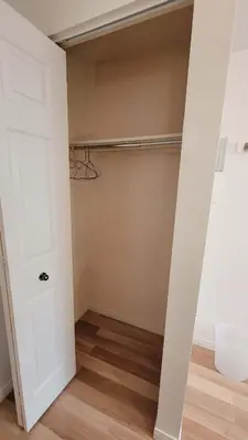 a room with a closet with white walls and wood floors at L'EMERAUDE sur la rivière Magog in Sherbrooke