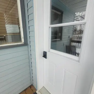 a white door with a window on a house at L'EMERAUDE sur la rivière Magog in Sherbrooke