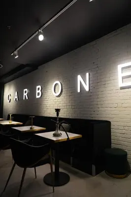 a restaurant with tables and chairs against a brick wall at Carbone in Montréal