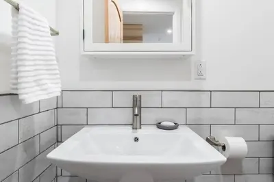 a white sink in a bathroom with a mirror at Unique 1847 Heritage Retreat - Garden - 2 Parkings in Montréal