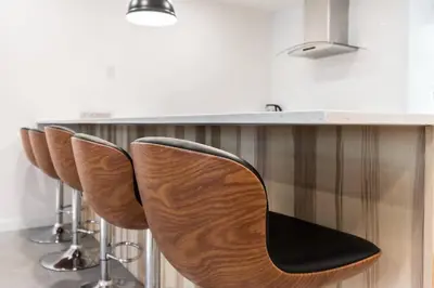 a row of chairs sitting at a bar in a kitchen at Unique 1847 Heritage Retreat - Garden - 2 Parkings in Montréal