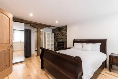 a bedroom with a large bed and a wooden floor at Unique 1847 Heritage Retreat - Garden - 2 Parkings in Montréal
