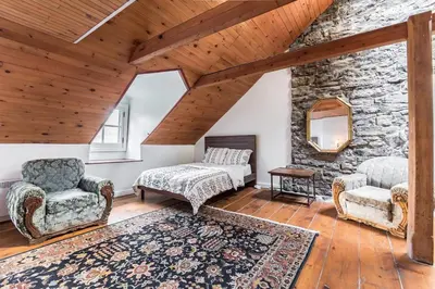 a living room with two chairs and a stone wall at Unique 1847 Heritage Retreat - Garden - 2 Parkings in Montréal