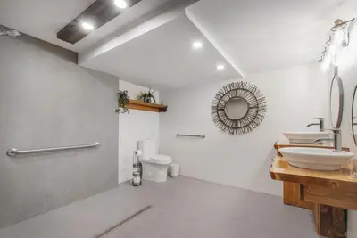 a white bathroom with two sinks and a mirror at auxportesdesMilleIles in Laval