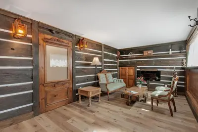 a living room with wood paneled walls and furniture at auxportesdesMilleIles in Laval