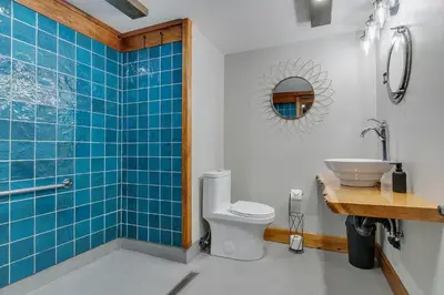 a bathroom with a toilet and a sink and blue tiles at auxportesdesMilleIles in Laval