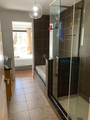 a bathroom with a glass shower with a tub at Beautiful bright apartment in Montréal