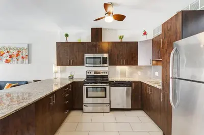 a kitchen with wooden cabinets and stainless steel appliances at Magnifique appartement Montréal Centre-Ville in Montréal
