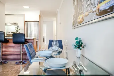 a dining room with a glass table and chairs at Appartement chaleureux pour un séjour parfait in Montréal